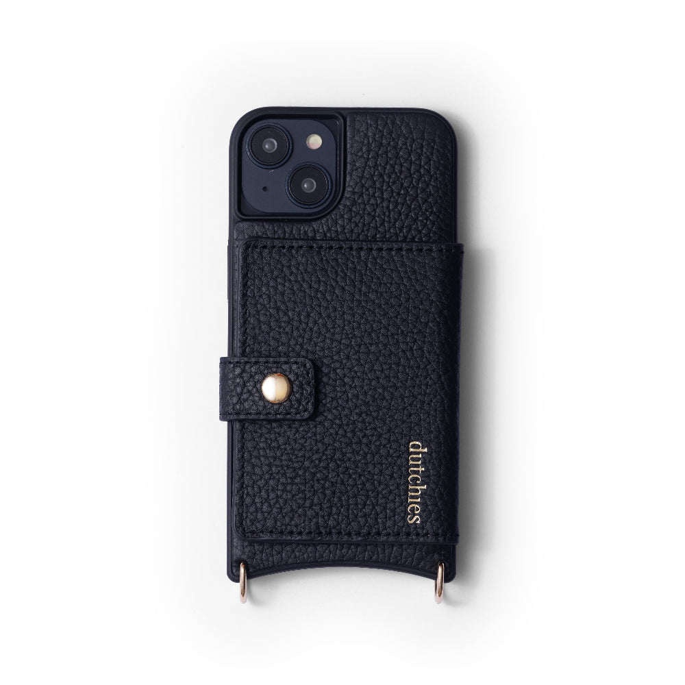 Una cover in pelle nera per iPhone con design Magsafe, con un ritaglio per la fotocamera in alto, una patta frontale e dettagli dorati. Il marchio 'Dutchies' è visibile sulla cover.