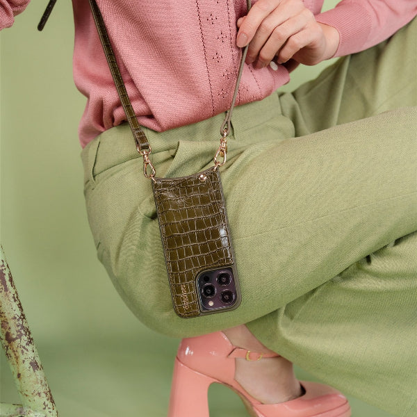 Classic set | iPhone | Olive Green styled with a pink top and green pants, showcasing a trendy phone case and strap.