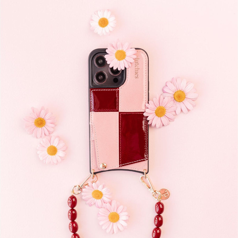 Funda para iPhone | Gloss Lollipop con tarjetero, adornada con flores sobre un fondo rosa.
