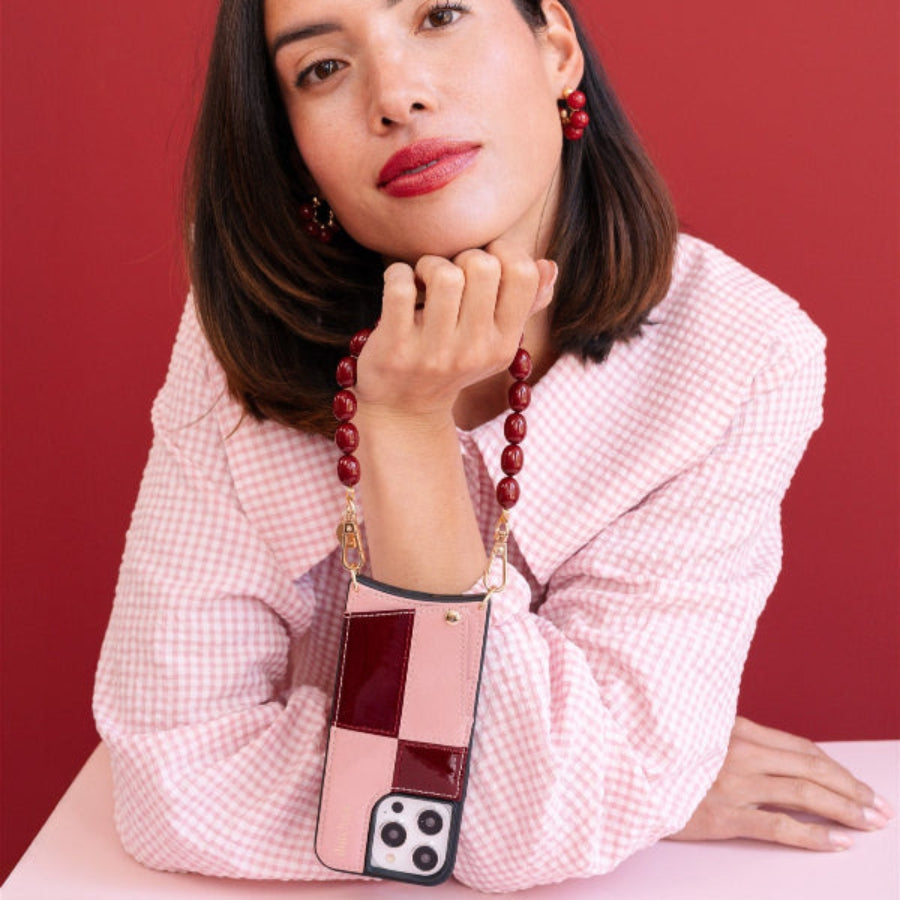 Accesorio de teléfono | De cuentas | Charley llevado por una mujer con un conjunto elegante, mostrando cuentas vibrantes y una funda para teléfono chic.