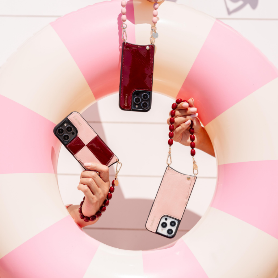 Accesorio de teléfono de cuentas y fundas para teléfono elegantes mostrados sobre un flotador a rayas rosas, perfectos para el verano.