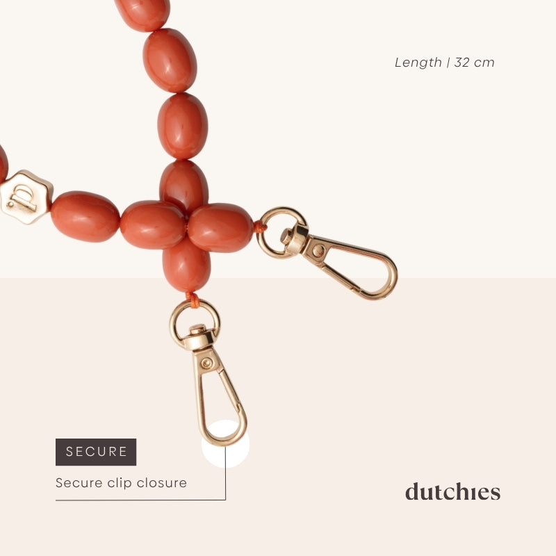 Bracelet Téléphone | Perlé | Gros plan sur Tamara avec une fermeture à clip sécurisée et de délicates perles orange.