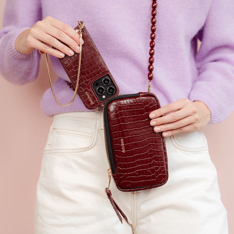 Phone Bag Rose | Burgundy displayed with a stylish purple sweater, showcasing its elegant design and functionality.