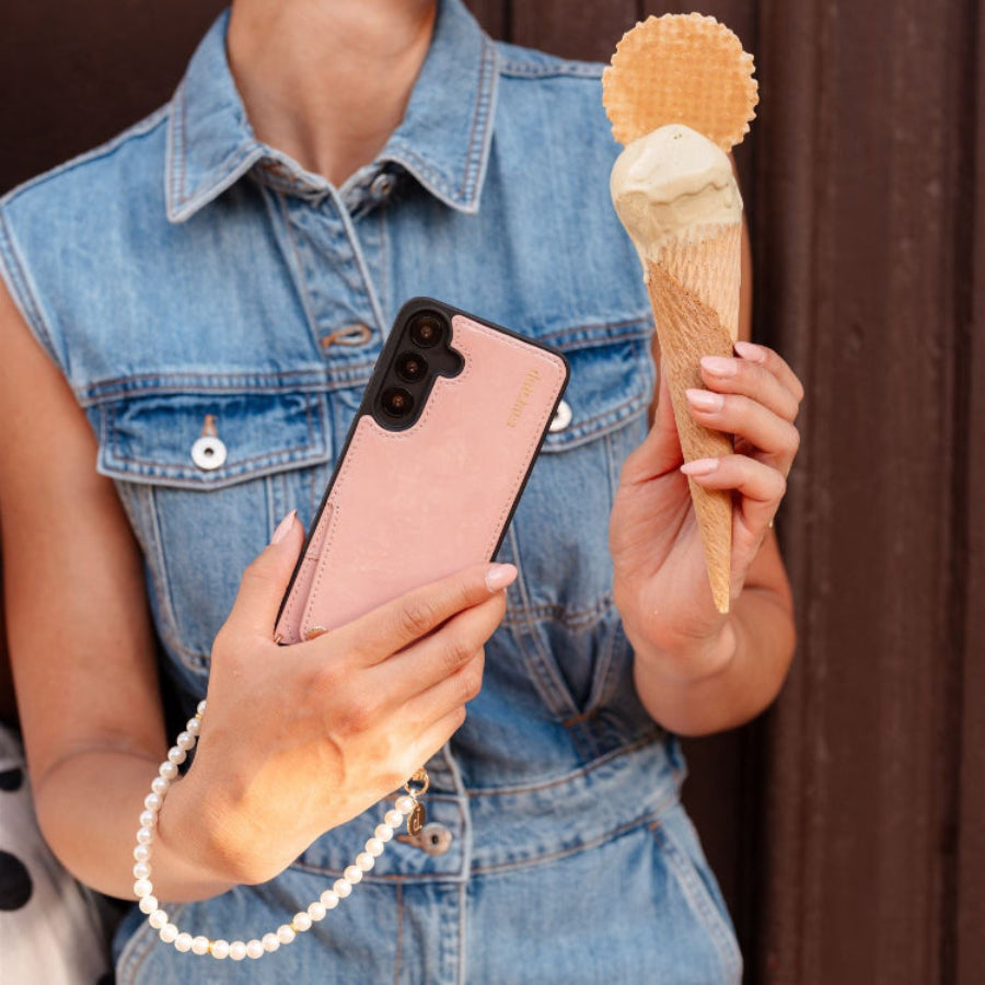 Frau, die eine Samsung-Hülle | Gloss Pink mit Kartenfach hält und an einem sonnigen Tag Eis genießt.