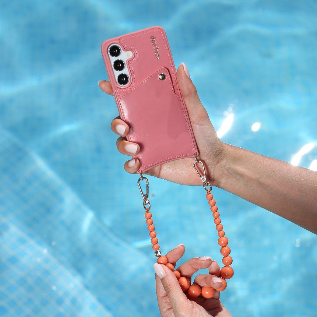 Samsung-Hülle | Pink mit Leder-Kartenhalter und Perlenriemen, stilvoll am Pool gehalten.