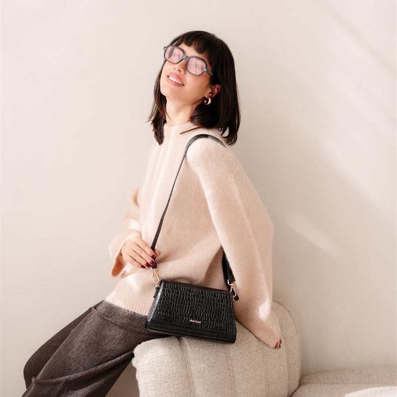 Sophie Crossbody Bag | Noir Gold indossata da una modella in un outfit cozy, perfetta come borsa per telefono per uscite di stile.