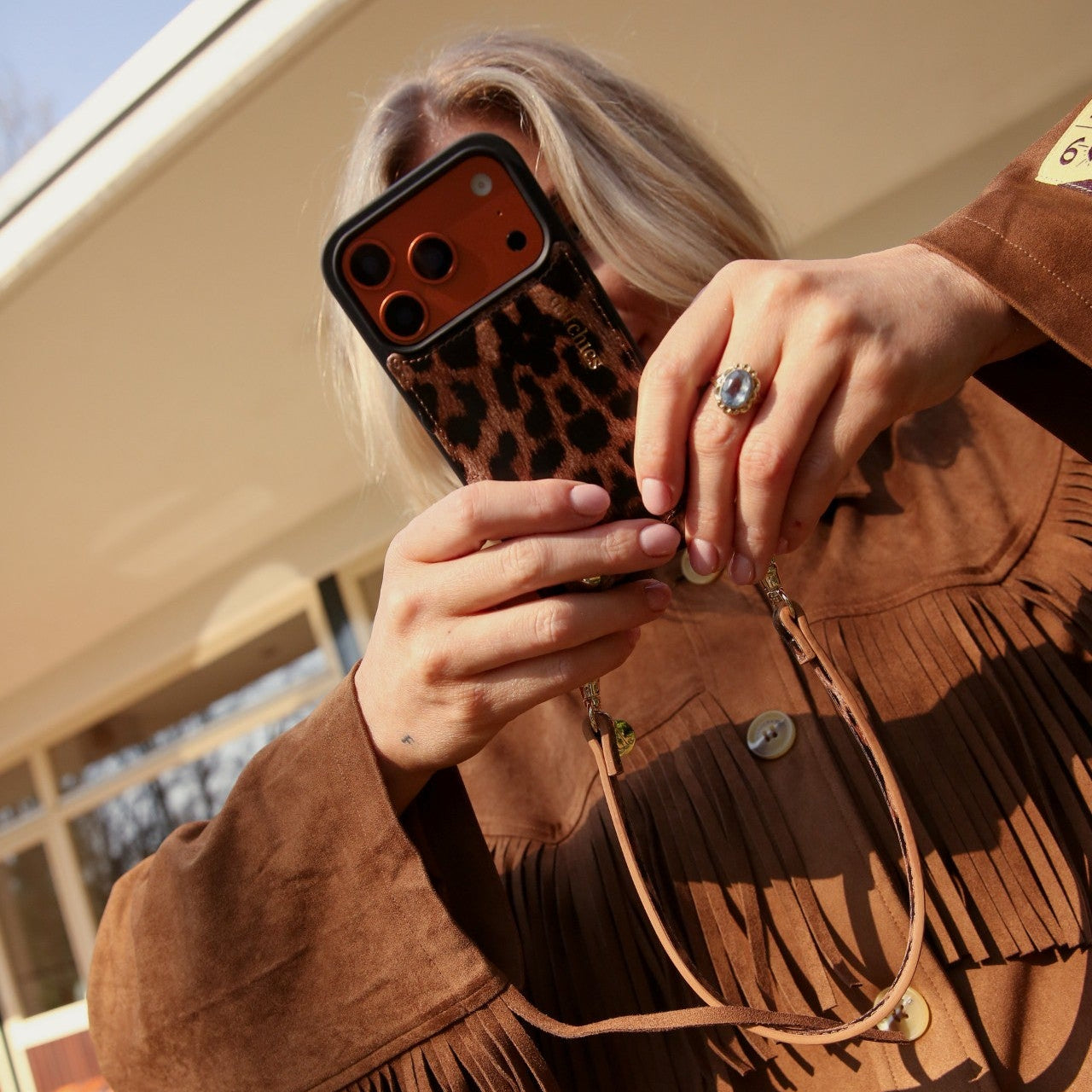 User holding an iPhone Case | Leopard with a stylish strap and a ring, showcasing a trendy look.