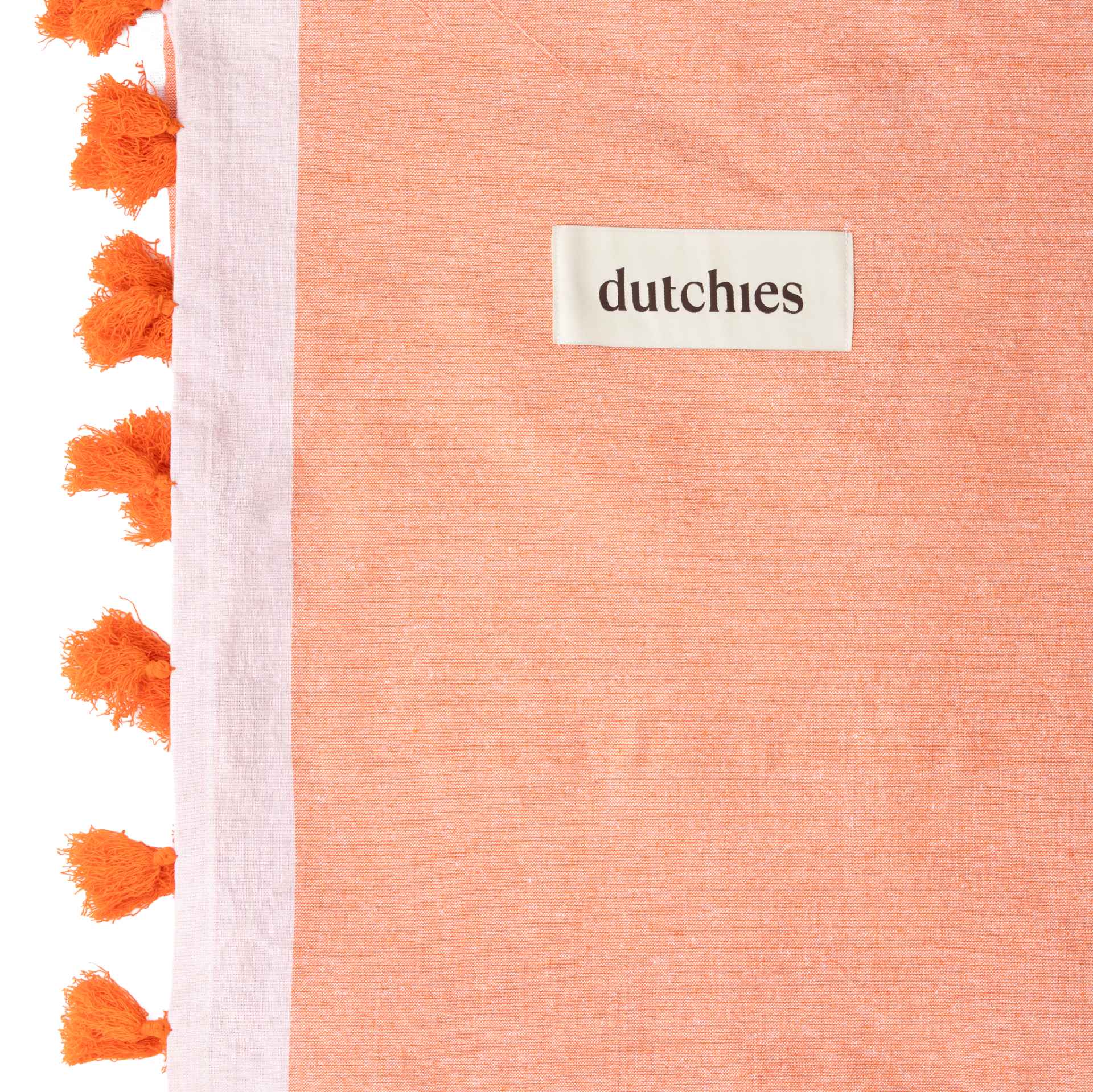 Close-up of an orange hammam towel with decorative tassels, perfect for your beach bag this summer.